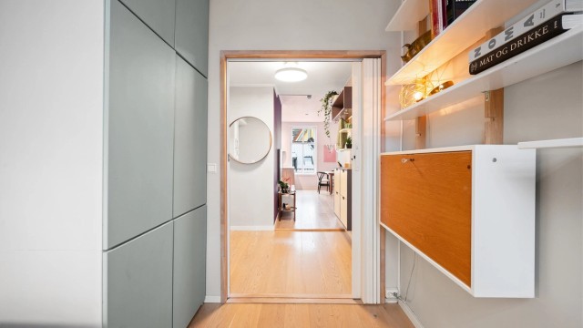 En plassbesparende trekkspilldør i heltre eik er montert for å utnytte arealet optimalt.