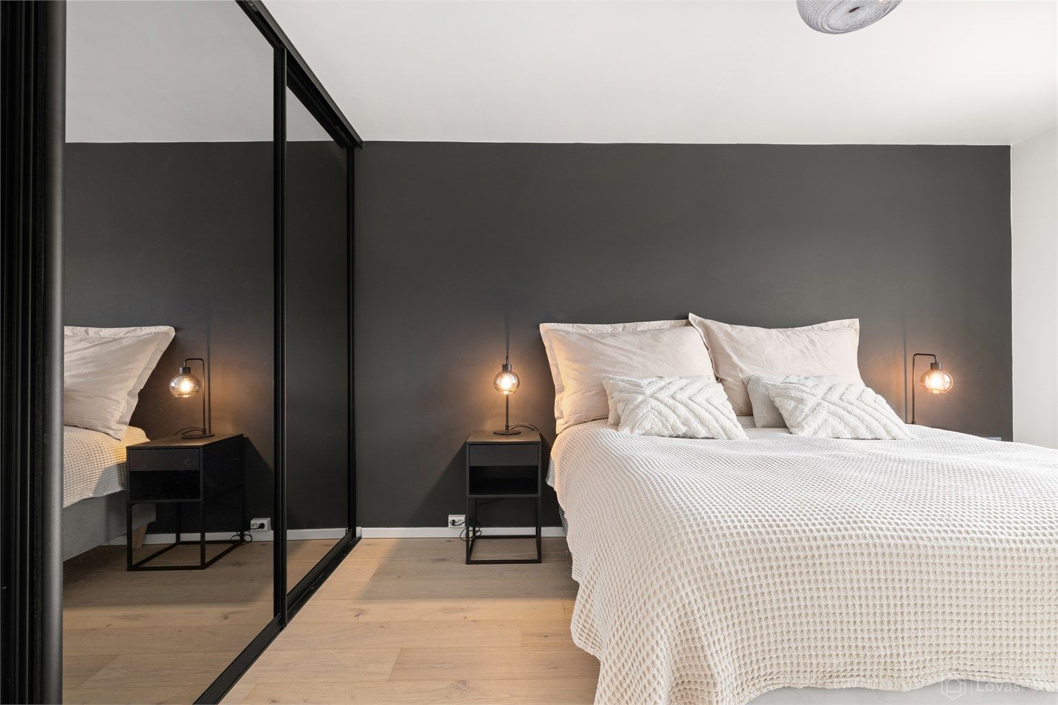 En stor skyvedørsgarderobe med speilfronter gir rikelig med oppbevaringsplass.