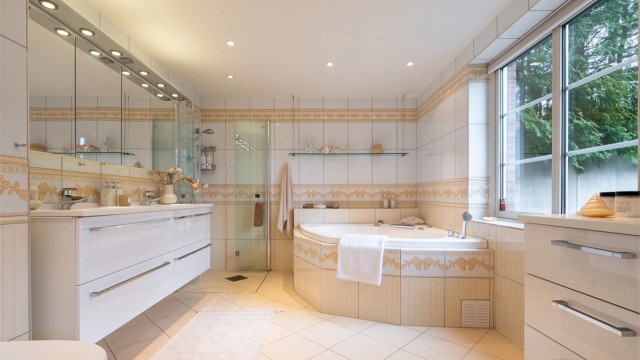 Romlig, flislagt bad med gulvvarme. Innredet med vegghengt servantskap med ovenpåliggende dobbeltvask, egen dusjnisje og innmurt boblebadekar.