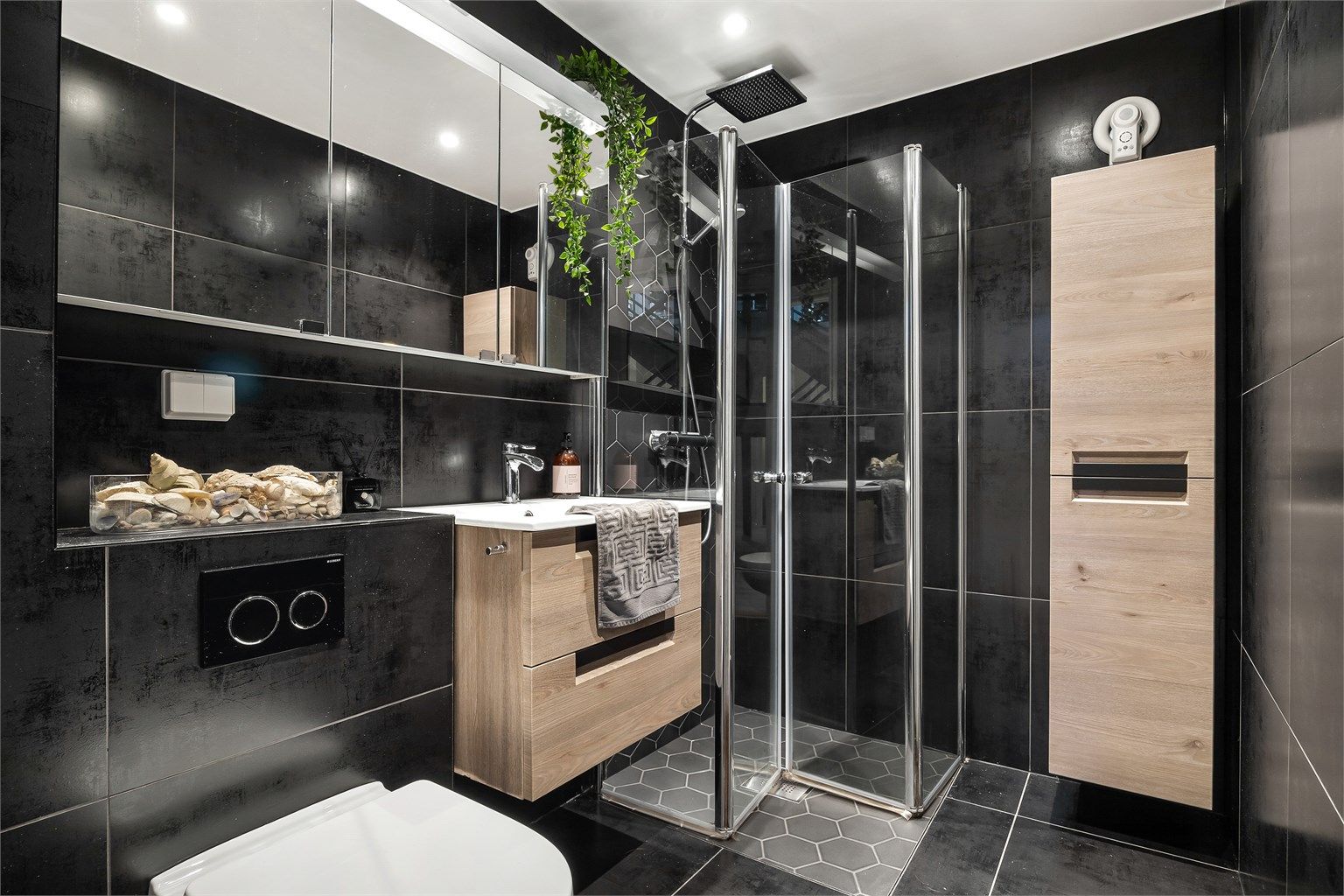 Badet i underetasjen er fra 2019, med fliser, gulvvarme, downlights og dusjhjørne med regnfallsdusj.