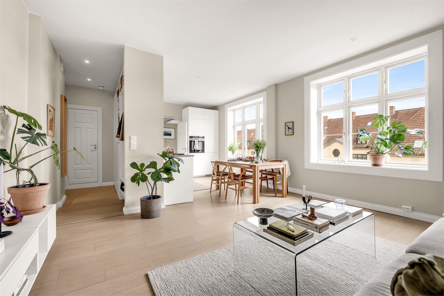 Åpen stue- og kjøkkenløsning med store vindusflater som sørger for rikelig med naturlig lys inn i leiligheten. Foto: Bjørnar Solberg. 