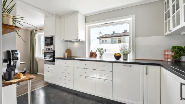 Fint kjøkken med innredning med profilerte fronter og benkeplate med laminert med nedfelt kjøkkenvask
