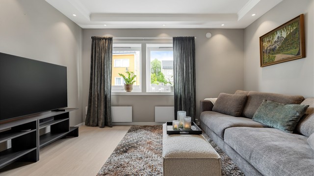Lys og pen stue med sofaområde samt spiseplass.