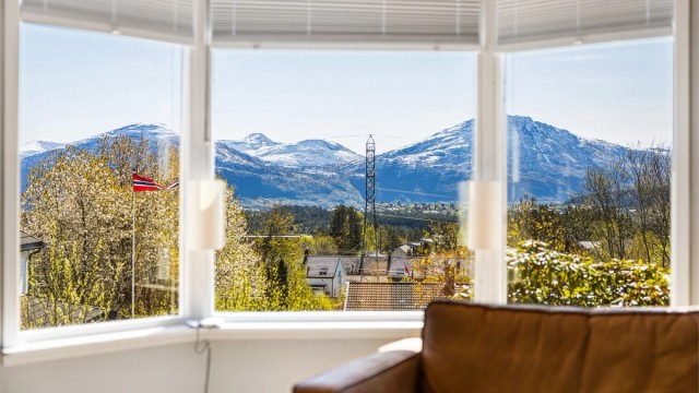 Stort karnappvindu på stue med flott utsikt mot fjellene
Foto: Odin Jæger