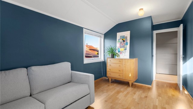 Det er stedbygd garderobe i vegg. Parkett på gulv og malte vegger.