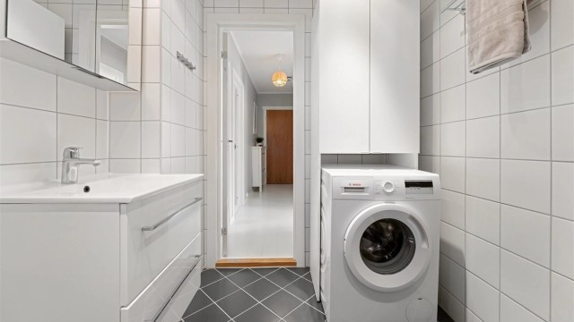 Her er det gulvvarme for komfort, vegghengt toalett og praktisk opplegg for vaskemaskin.