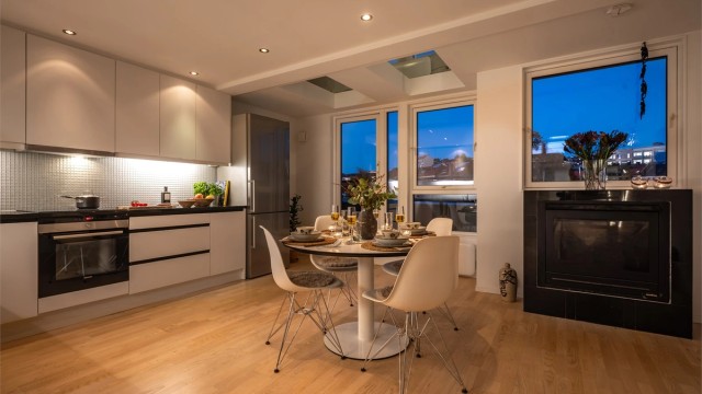 Kveldsstemning på kjøkkenet med integrerte downlights og dør ut mot balkongen.
