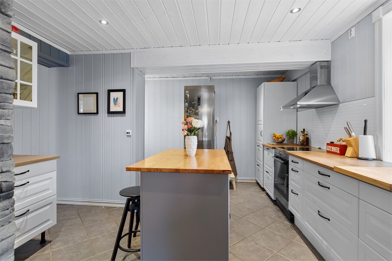 Pent kjøkken med innredning med profilerte fronter og laminert benkeplate. Flislagt gulv med varme.