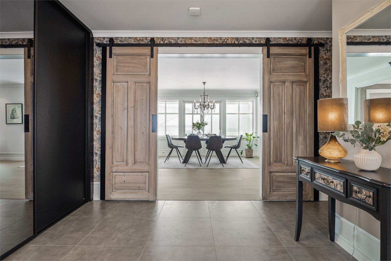 Fra entréen åpner doble skyvedører seg inn mot spisestuen og stuen.