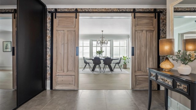 Fra entréen åpner doble skyvedører seg inn mot spisestuen og stuen.