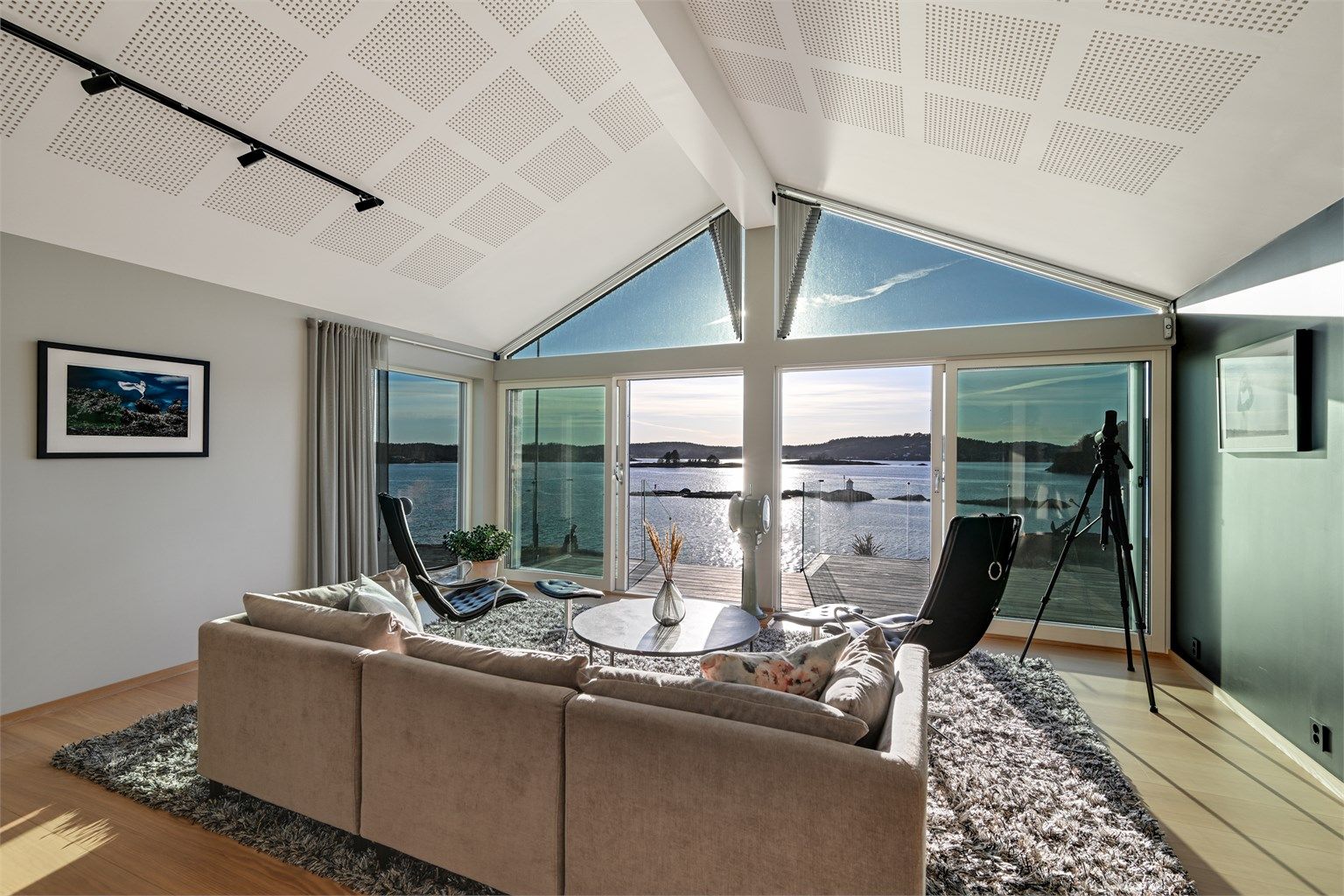 Det er adkomst ut til den flotte terrassen og hagen. Her får du sjøen rett inn i stuen. 