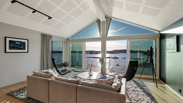 Det er adkomst ut til den flotte terrassen og hagen. Her får du sjøen rett inn i stuen.