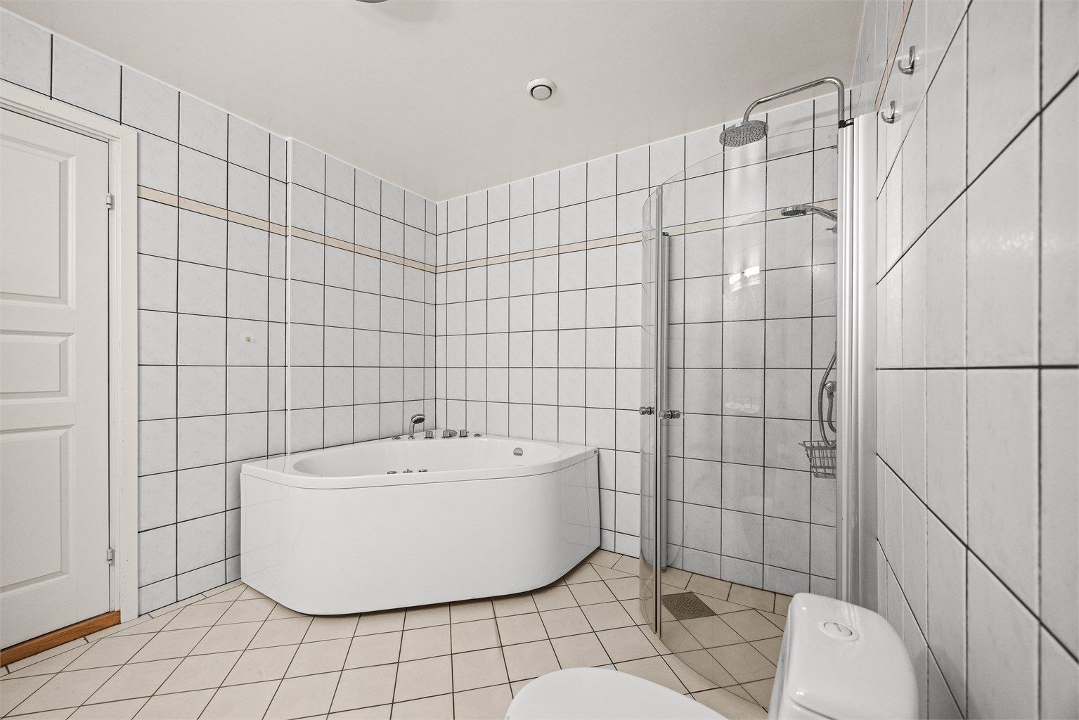 Badet har både dusjhjørne og et romslig hjørnebadekar.