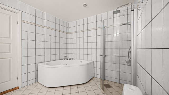 Badet har både dusjhjørne og et romslig hjørnebadekar.