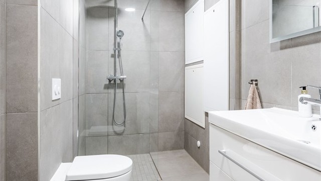 Dette badet har også vannbåren gulvvarme, vegghengt toalett og dusjhjørne.