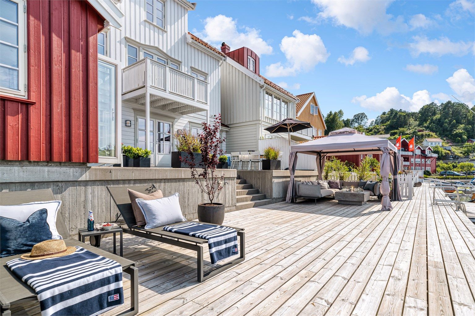 Stor og fin brygge med plass for solsenger, spisebord og loungegrupper