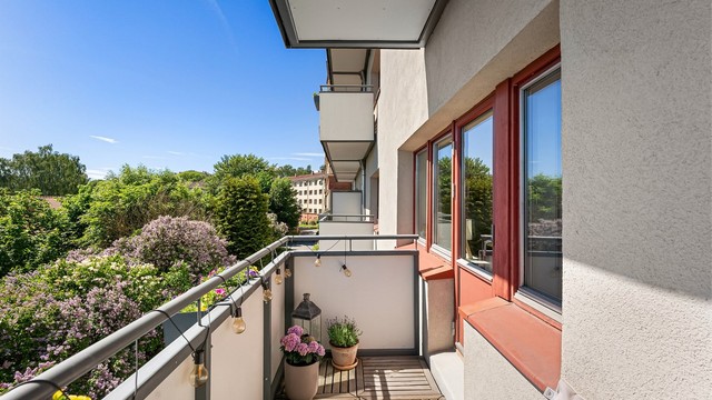 Balkongen vender ut mot borettslagets grønne og rolige fellesarealer.