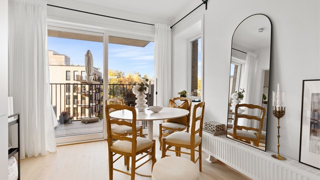 God plass til spisebord ved de store vindusflatene og skyvedøren ut til den sydvendte balkongen.