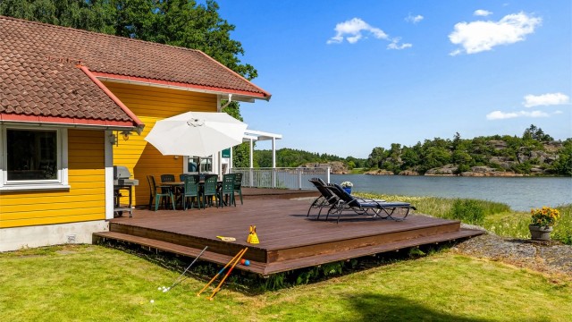 Hytta har en stor flott terrasse med nydelig utsikt til sjøen. Her sitter du lunt og usjenert til, så alt ligger til rette for og nyete varme sommerdager og senere sommerkvelder.
