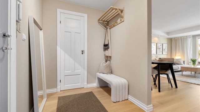 Velkommen inn i en lys entré med porttelefon og god plass til yttertøy.