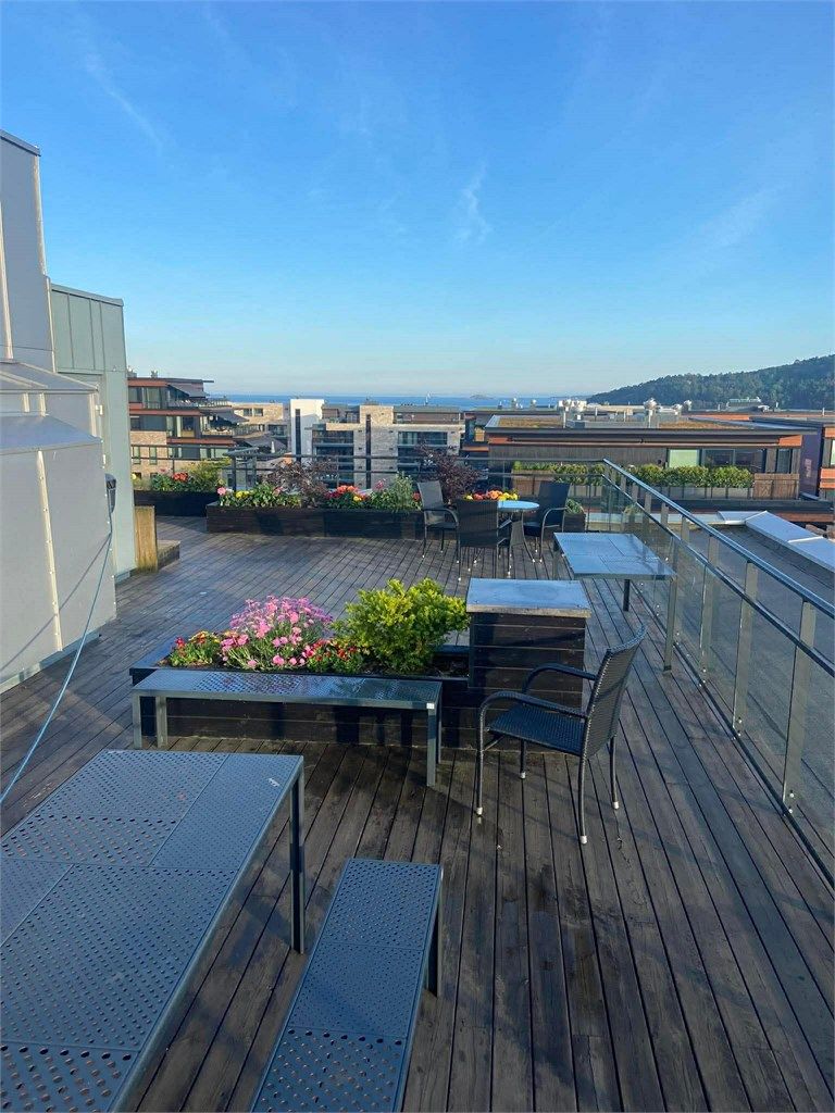 Sameiet har en felles takterrasse som kan benyttes fritt av beboere. Terrassen har flere hyggelige sitteplasser. (Selgers bilde)
