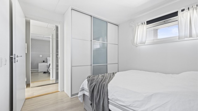 Skyvedørsgarderobe med plass til klær. Laminat på gulv