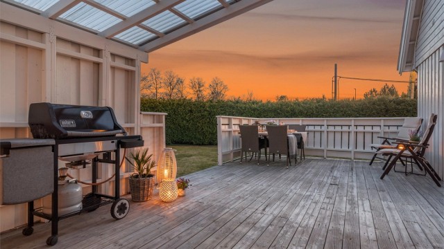 Stor, solrik og delvis overbygget terrasse med adkomst videre til en flat og velstelt hage