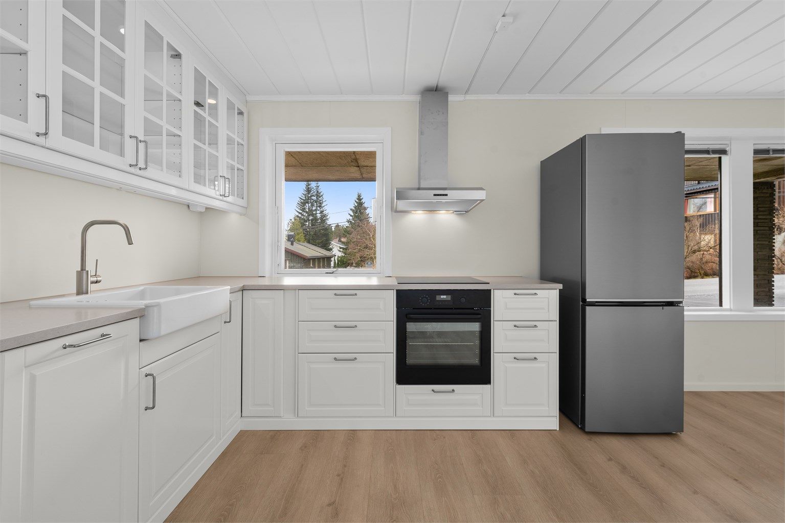 Kjøkkenet er utstyrt med integrert stekeovn, induksjonstopp og en elegant benkeplate i Nerostein.