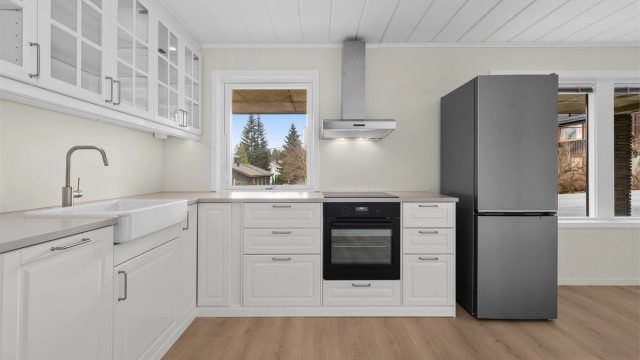 Kjøkkenet er utstyrt med integrert stekeovn, induksjonstopp og en elegant benkeplate i Nerostein.