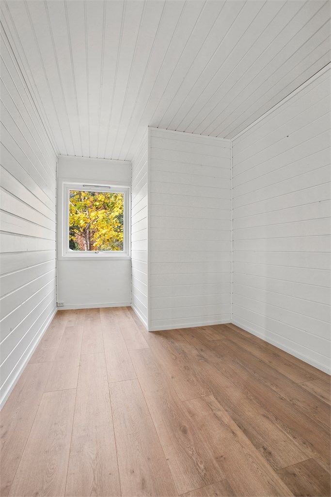 Soverom i tilknytning til stuen, med laminatgulv og malte panelvegger.