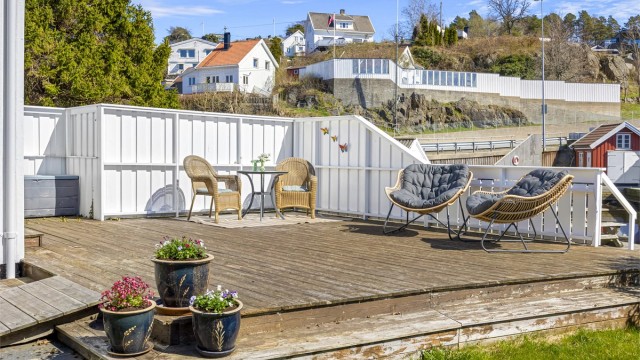 Boligen har terrasse på bakkeplan med direkte utgang fra stuen og takterrasse over tilbygg.