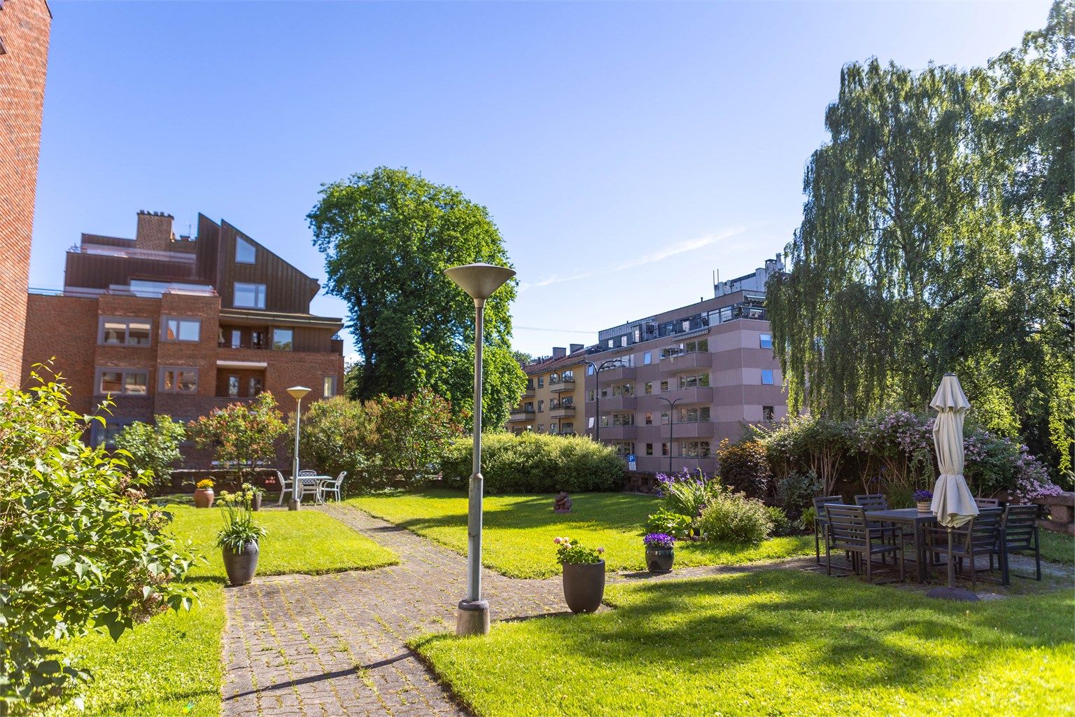 Felleshagen er pent opparbeidet med flere sittegrupper som inviterer til rolige stunder utendørs.