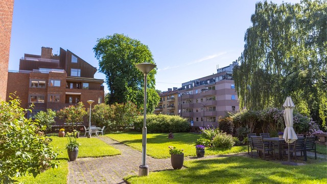 Felleshagen er pent opparbeidet med flere sittegrupper som inviterer til rolige stunder utendørs.