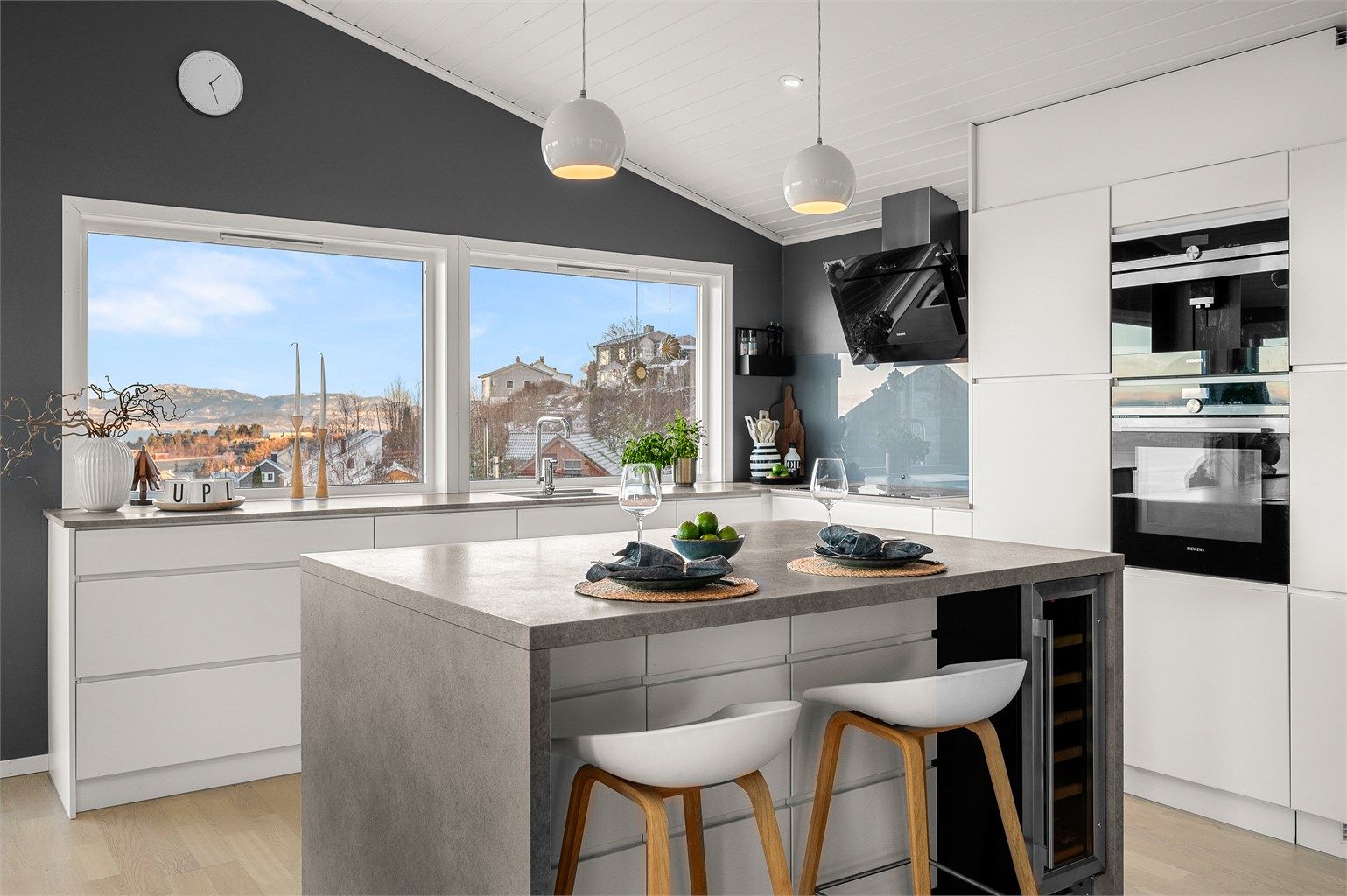 Integrerte hvitevarer og vinskap i kjøkkenøyen gir et helhetlig og gjennomført uttrykk.