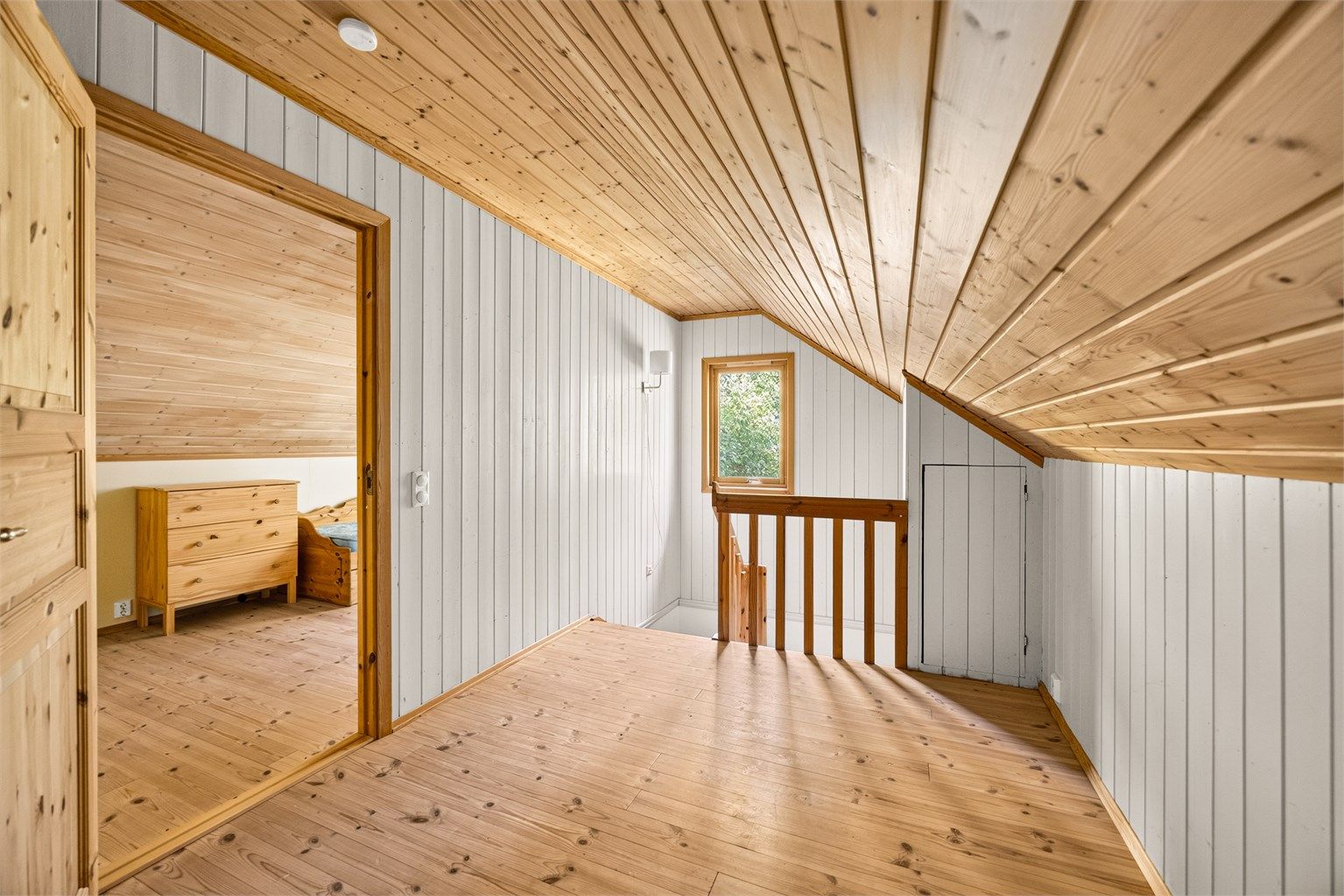 Loftsetasjen har malt panel på vegger og panel i skråtak.