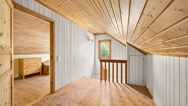 Loftsetasjen har malt panel på vegger og panel i skråtak.