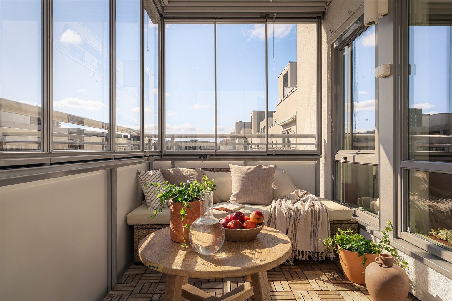 Glassfeltene på balkongen kan enkelt skyves til side for å åpne opp på varme dager. Gulvet er belagt med trefliser.