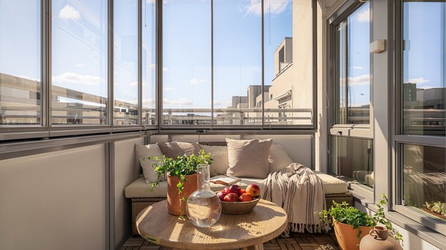 Glassfeltene på balkongen kan enkelt skyves til side for å åpne opp på varme dager. Gulvet er belagt med trefliser.