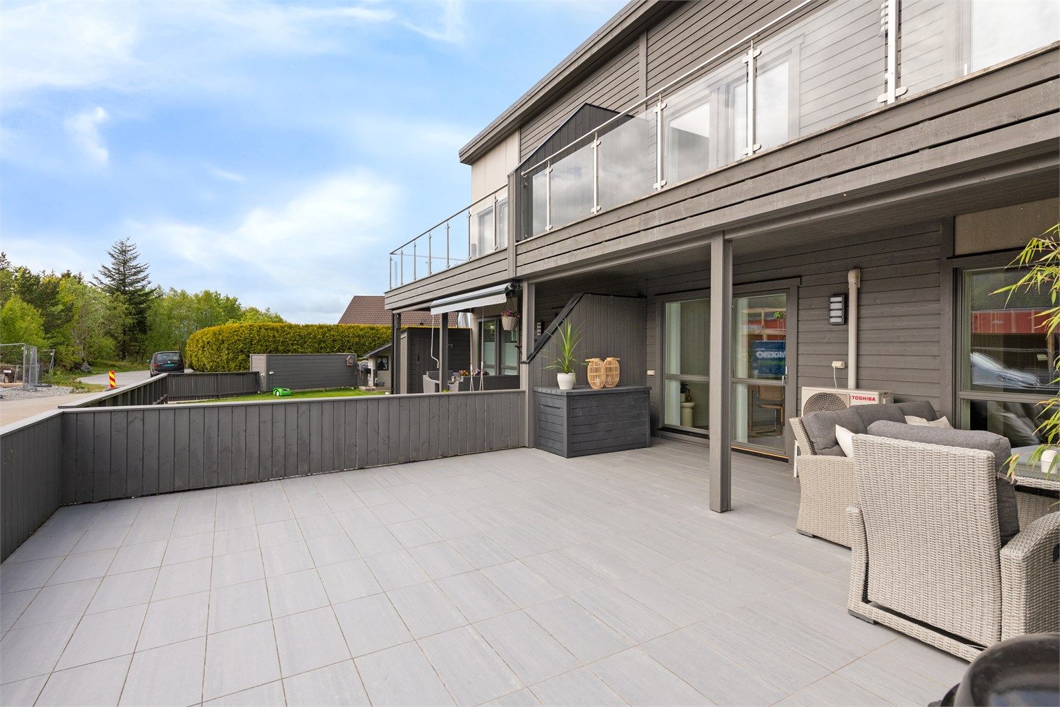 Stor sørvendt markterrasse skjermet med gjerde og levegg mot naboer