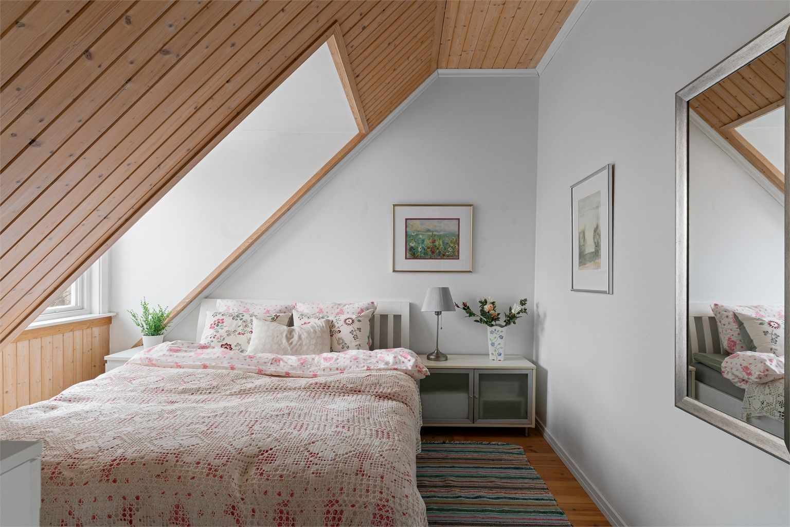 Sjarmerende soverom med skråtak og god plass til dobbeltseng med tilhørende møblement.