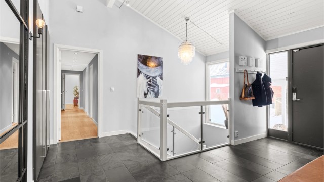 Boligen ønsker deg velkommen med en lys og generøs entré som setter tonen for resten av hjemmet. Gulvet er belagt med fliser med behagelig gulvvarme.