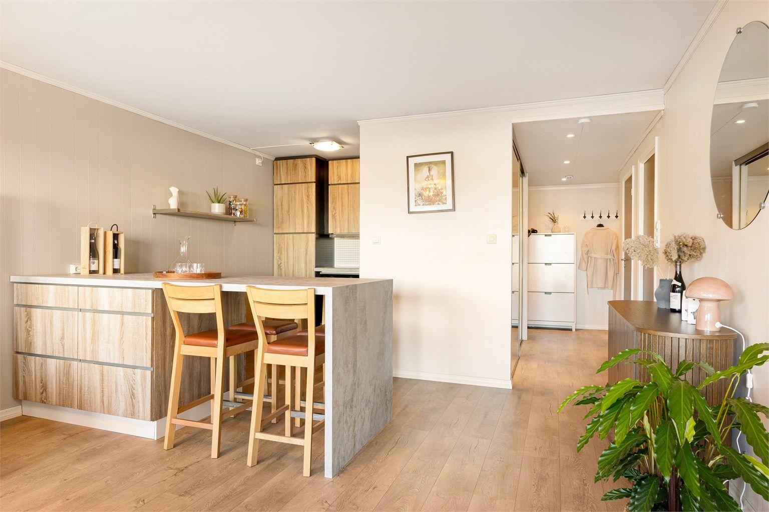 Kjøkkenet ligger i åpen løsning mot stue hvor det er laget et praktisk skille med kjøkkenøy som også fungerer som spisebord og gir ekstraoppbevaringsplass.