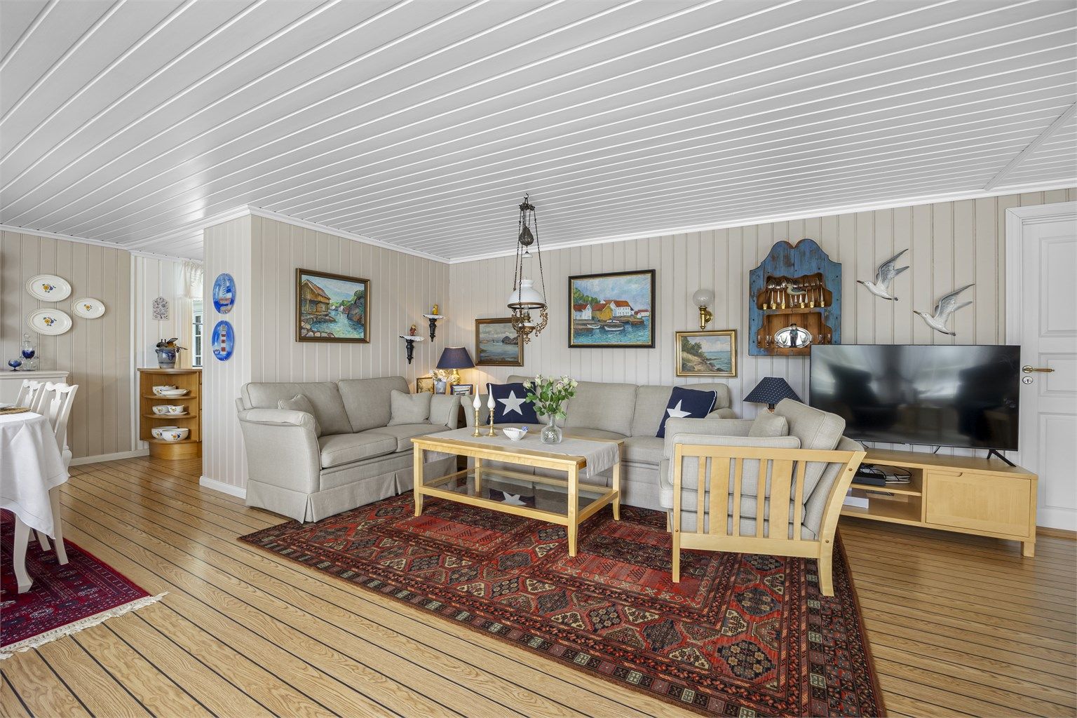 Romslig stue med plass til flere sittegrupper.