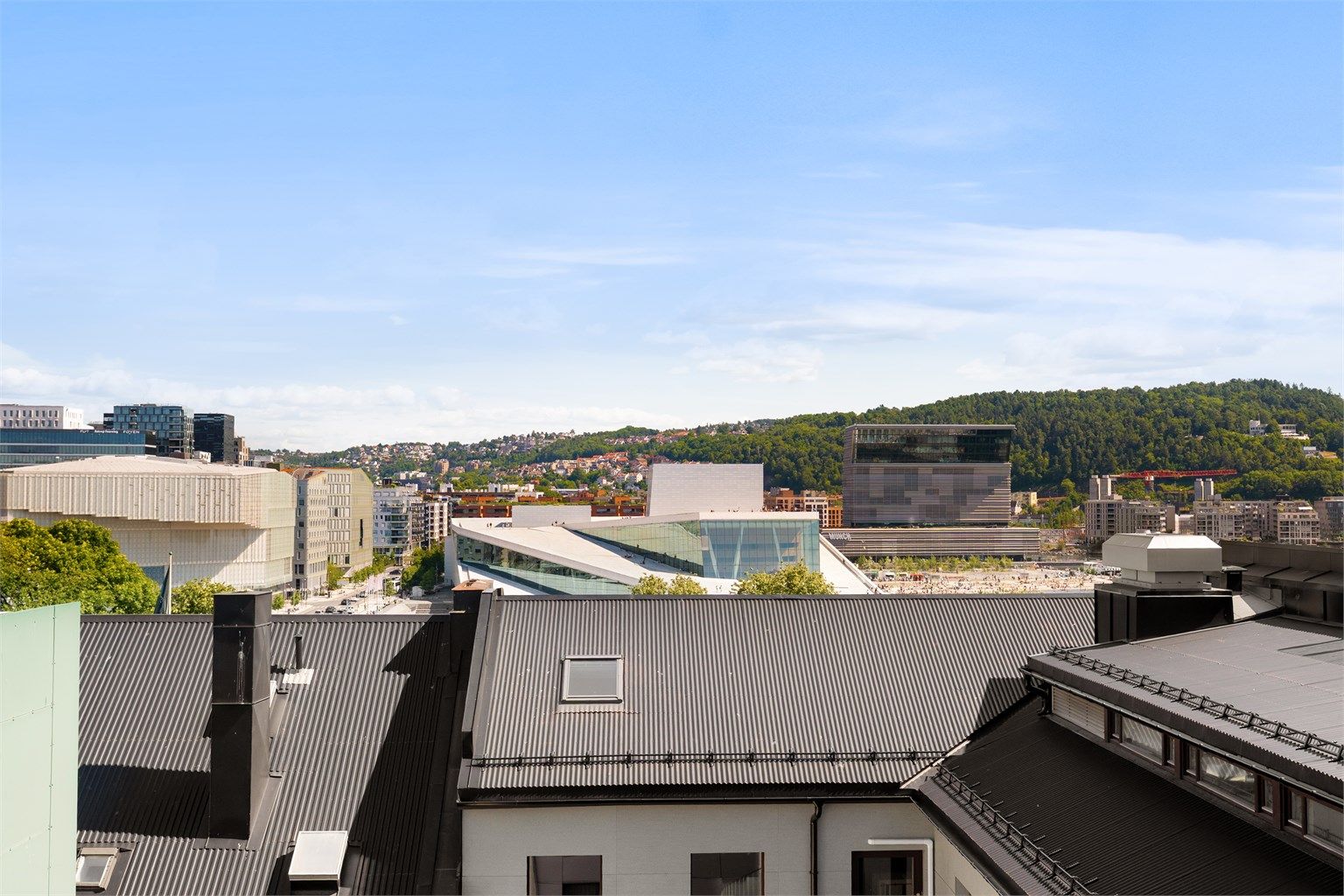 Fra takterrassen har man unik utsikt mot flere av Oslos severdigheter. Her med Nasjonalbiblioteket, Operahuset og Munch museet.