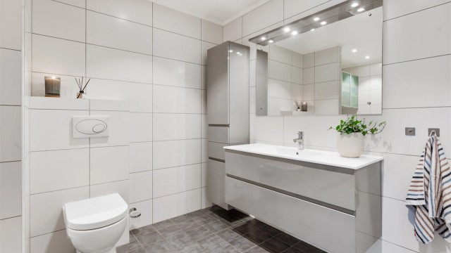 Badet er utstyrt med dusjkabinett med regnfallsdusj og vegghengt toalett.
