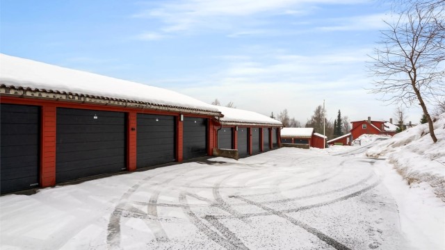 Parkering for en bil i felles garasjeanlegg. Garasjen har elbil-lader