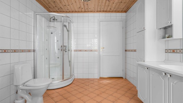 Badet har flislagt gulv med gulvvarme og flislagte vegger.