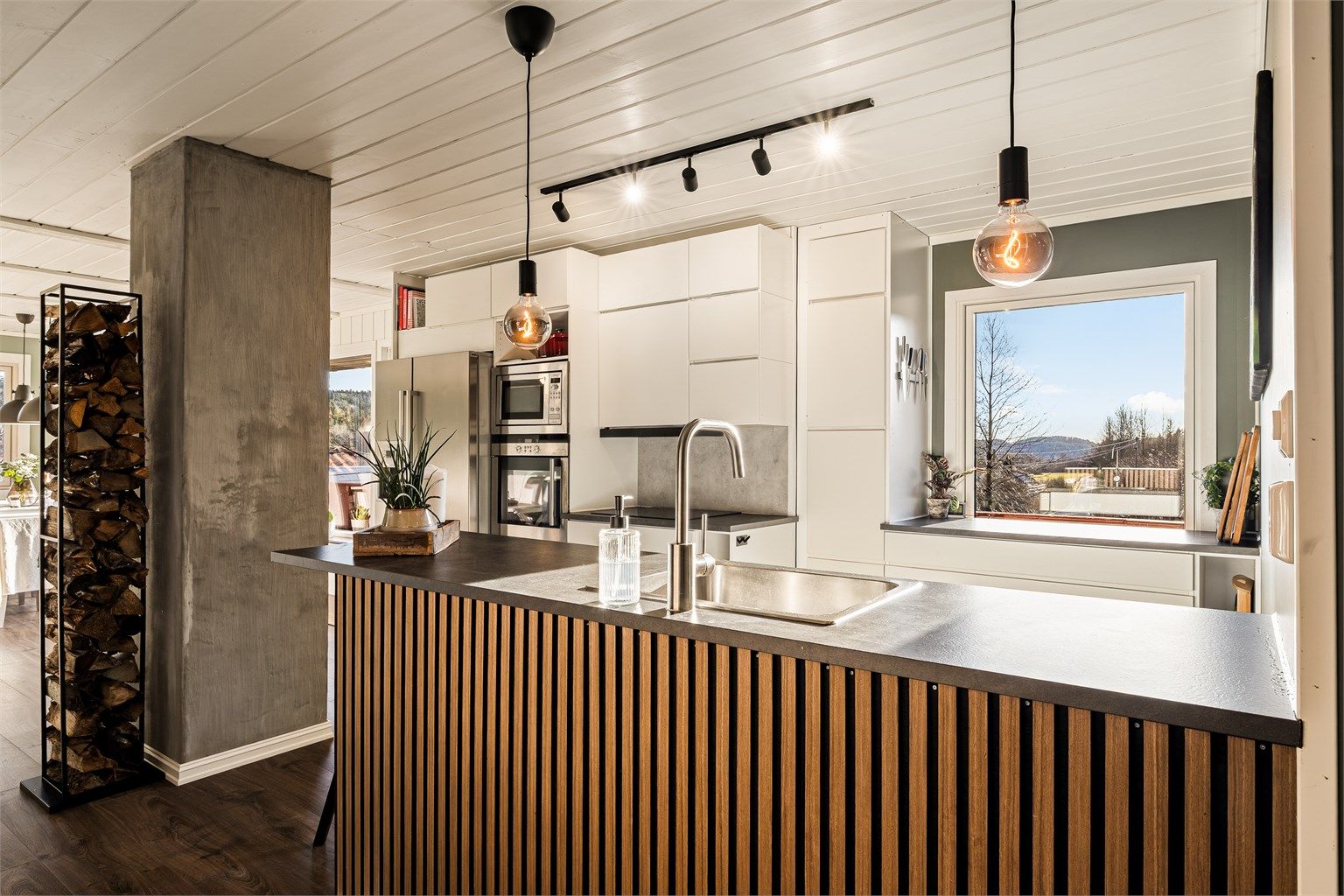 Kjøkkenet ligger i delvis åpen løsning mot stuen og har godt med både skap og benkplass