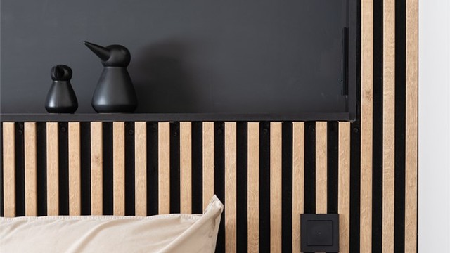 Den integrerte hyllen i spileveggen fungerer som en smart og dekorativ sengegavl.