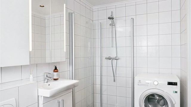 Badet er innredet med dusjhjørne med innfellbare glassdører og har opplegg for og plass til både vaskemaskin og tørketrommel.